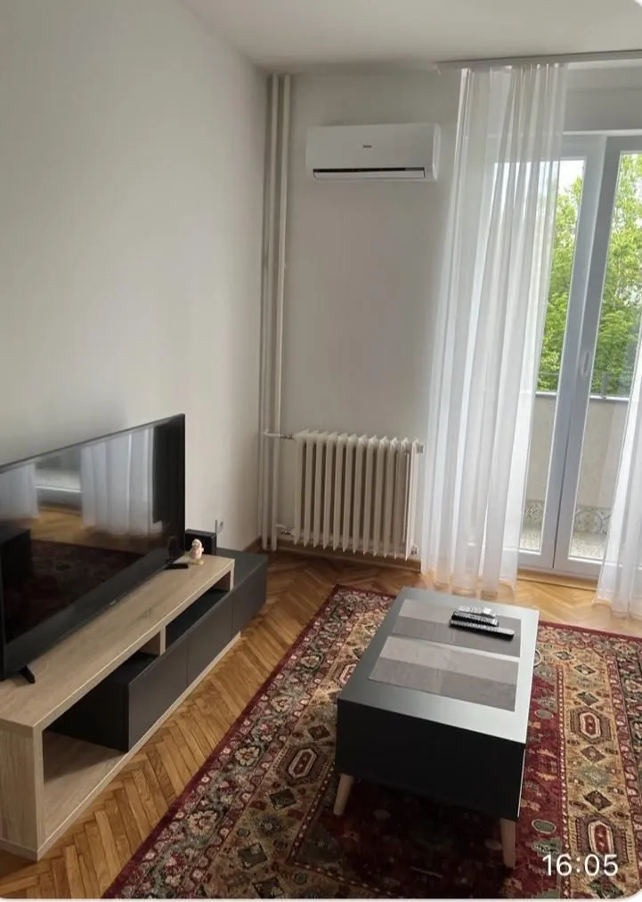 Living room with a TV, coffee table, and access to the terrace.