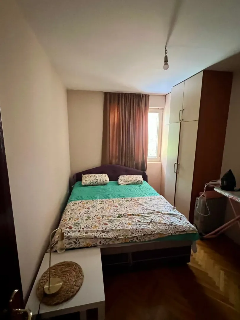 Furnished bedroom with a double bed, wardrobe, and window.