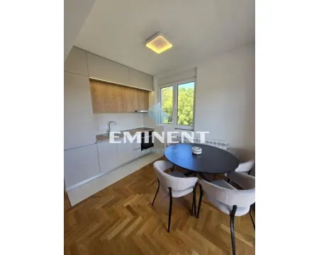 Modern kitchen with a dining table and hardwood flooring. - image 3