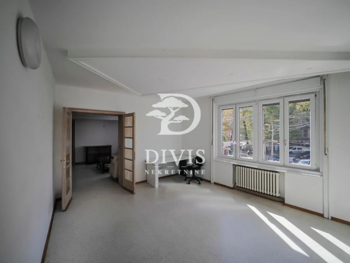 Empty room with a large window and doors leading to the adjacent room.