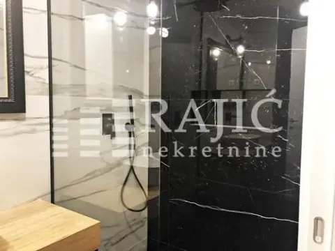 Modern bathroom with a walk-in shower and black and white marble tiles. - image 13