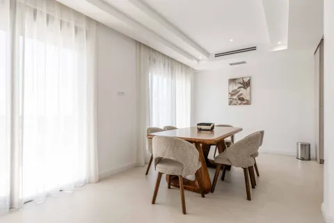 Dining area with a wooden table and upholstered chairs near large windows. - image 20