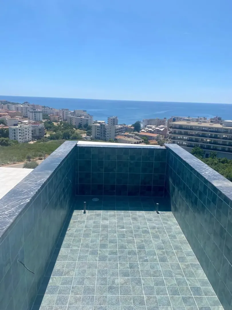 View of the city and sea from the terrace with a section of the pool.