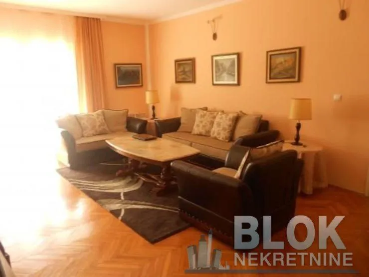 Spacious living room with a seating set, coffee table, and pictures on the wall.