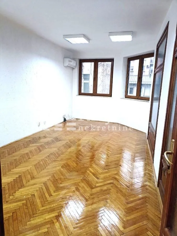 Empty room with parquet flooring and white walls.