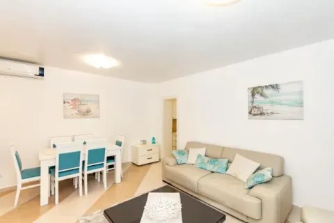 Living room with sofa and dining area. - image 3