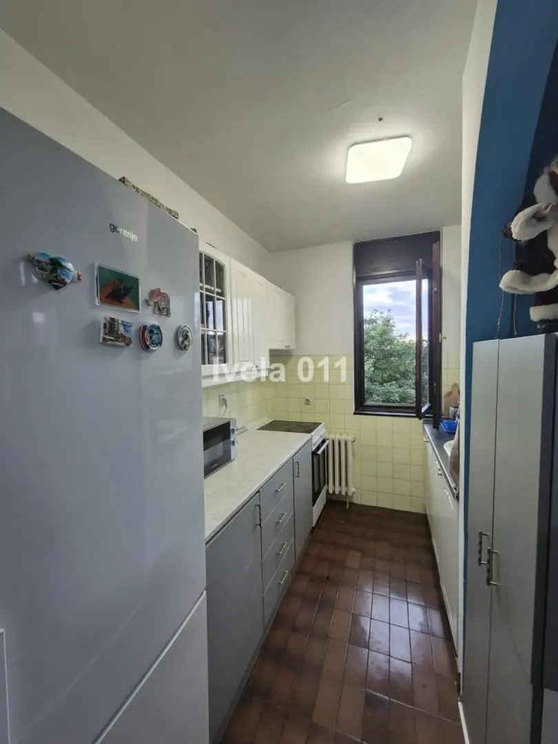 Small kitchen equipped with a refrigerator, stove, and upper and lower cabinets.