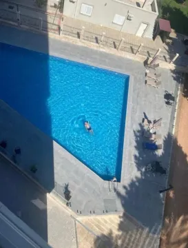High-angle view of the swimming pool with sun loungers and surrounding area. - image 12