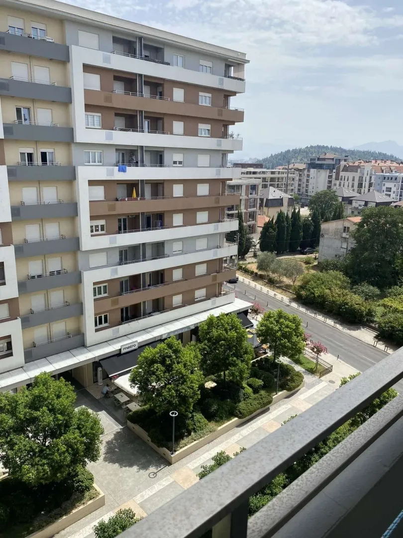 View from the balcony overlooking the neighboring building and surrounding greenery.