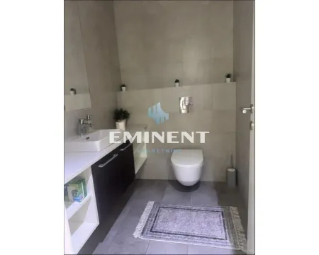 Modern bathroom with a sink, toilet, and grey tiles. - image 4