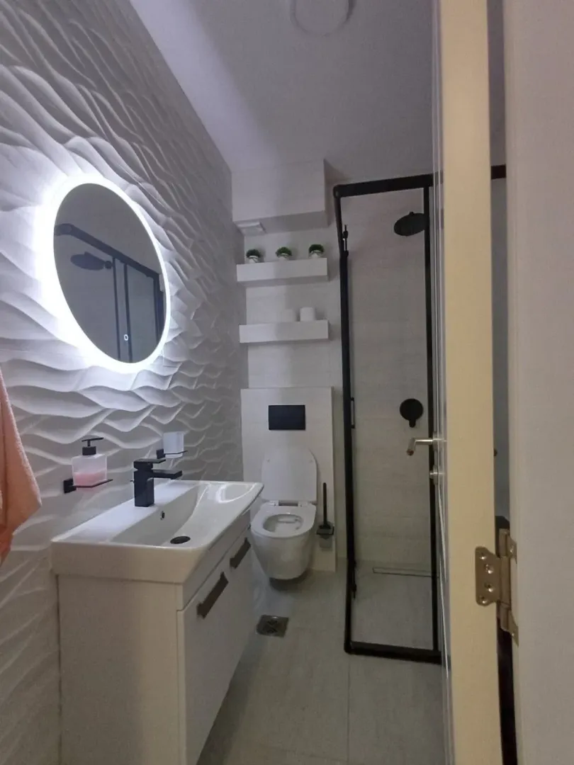Moderne kupatilo sa umivaonikom, tuš kabinom i ugradnim wc šoljom.