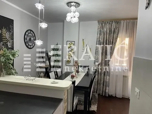 Living room with dining area and modern lighting.