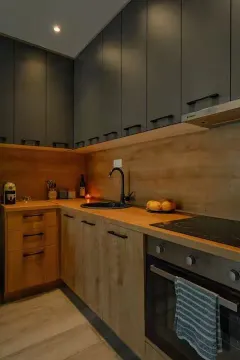 Modern kitchen with dark upper cabinets and wooden countertops. - image 4