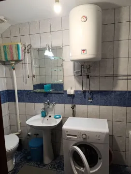 Smaller bathroom with a sink, toilet, water heater and washing machine. - image 9