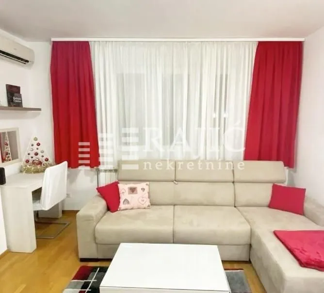 Living room with a sectional sofa, white coffee table, and a desk.