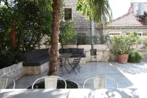 Paved courtyard with seating furniture and Mediterranean plants. - image 2