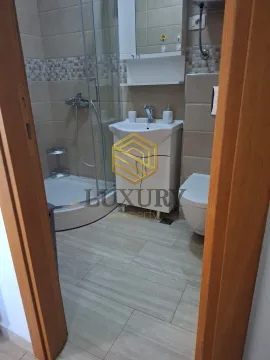 Pogled iz hodnika na uređeno kupatilo sa tuš kabinom. - image 9
