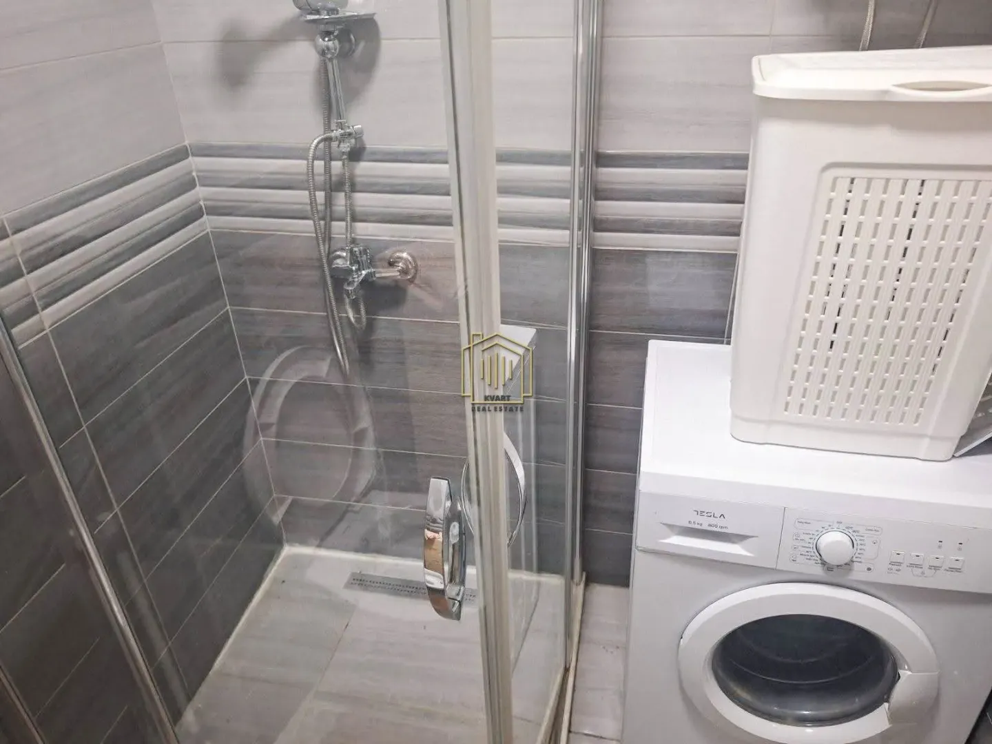 Bathroom with a shower cabin and a washing machine.