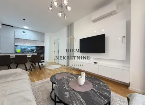 Living room with sofa, TV and a view towards the kitchen with dining area. - image 2