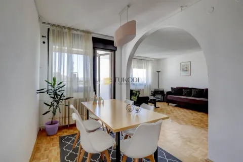 Dining area with a wooden table and white chairs connected to the living room. - image 8