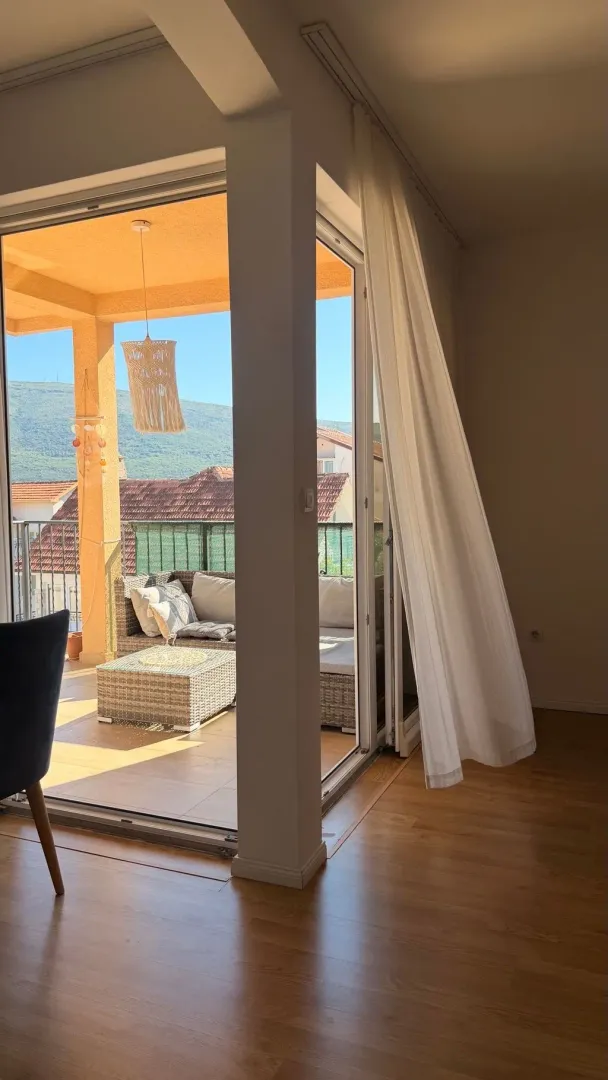 Pogled iz svijetlog enterijera na namještenu terasu sa garniturom za sjedenje.