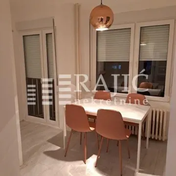 Dining room with a table, chairs, and a hanging lamp. - image 6