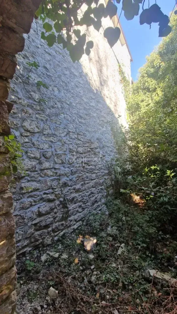 Pogled na kameni zid i dvorište ispred objekta.