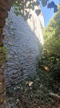 Pogled na kameni zid i dvorište ispred objekta. - image 2