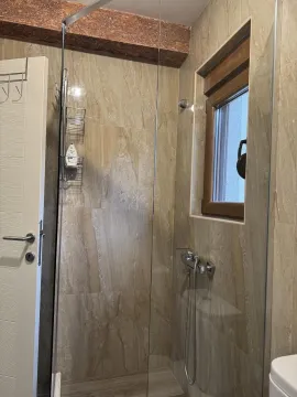 Moderan tuš sa staklenom pregradom i bež pločicama u kupatilu. - image 7