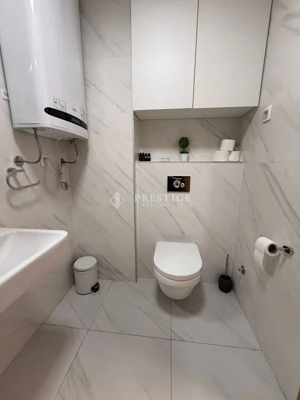 Moderne opremljeno kupatilo sa bijelim pločicama i sanitarijama.