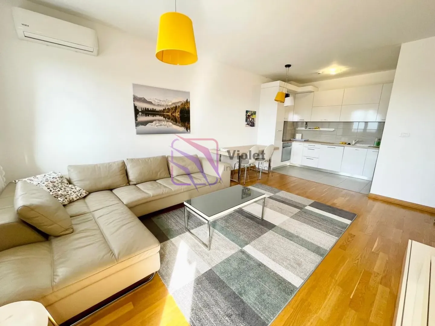 Living room with sofa and dining area connected to the kitchen.