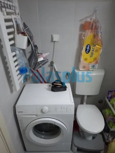 Kupatilo opremljeno toaletom i veš mašinom.