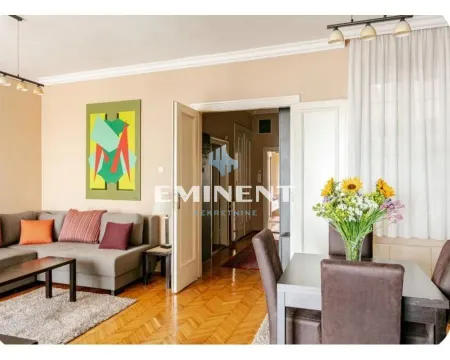 Living room with a sofa, dining table, and a view of the hallway. - image 20