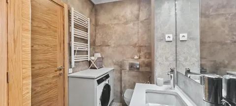 Moderno opremljeno kupatilo sa veš mašinom i velikim ogledalom. - image 4