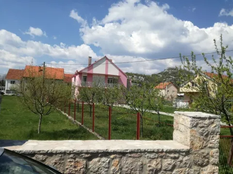 Vanjski izgled dvospratne kuće sa dvorištem pod plavim nebom. - image 3