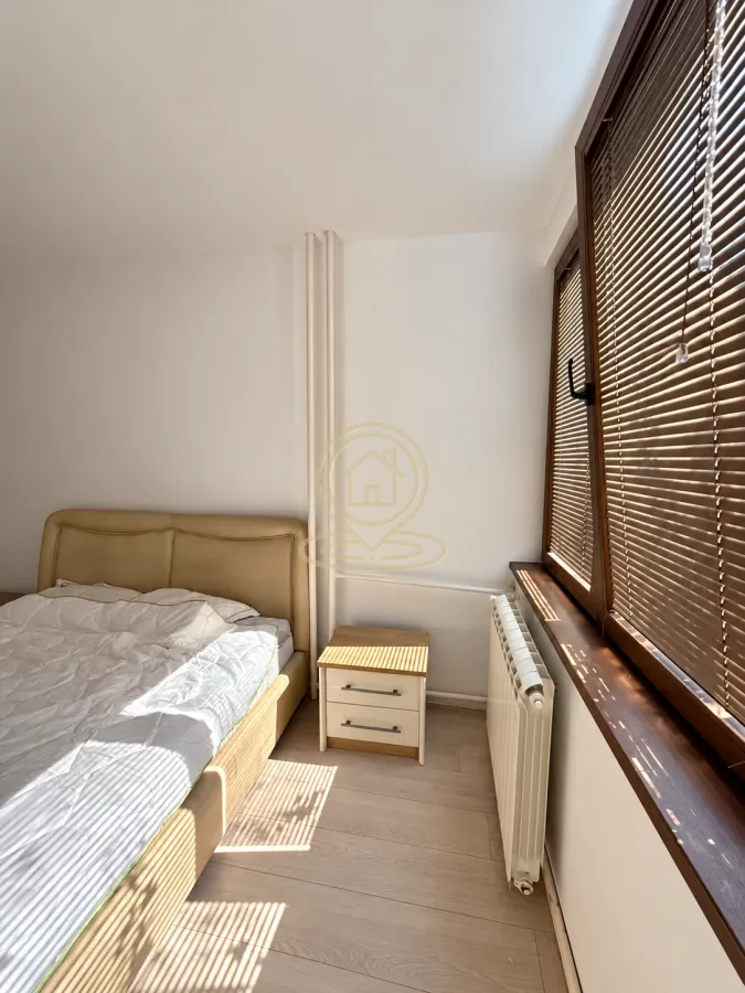 Bedroom with a bed, nightstand, and a window with blinds.