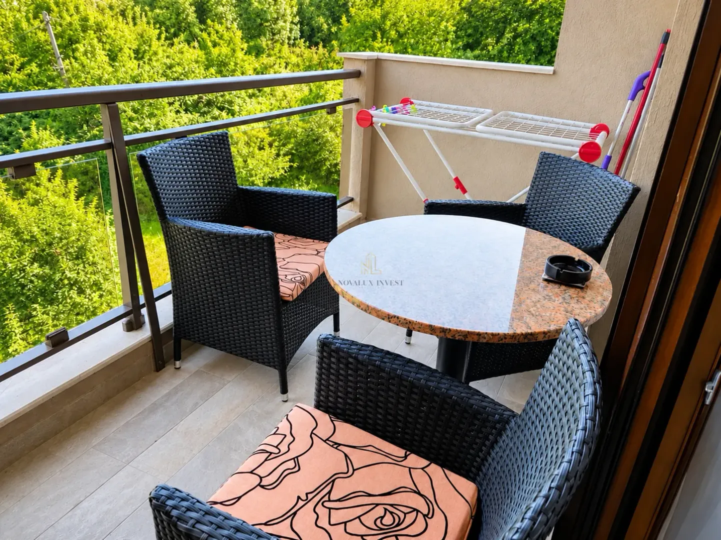 Namješten balkon sa garniturom za sjedenje i pogledom na zelenilo.