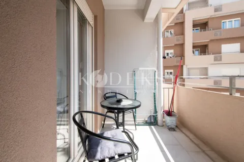 Furnished balcony with a table and chairs and a view of surrounding buildings. - image 8