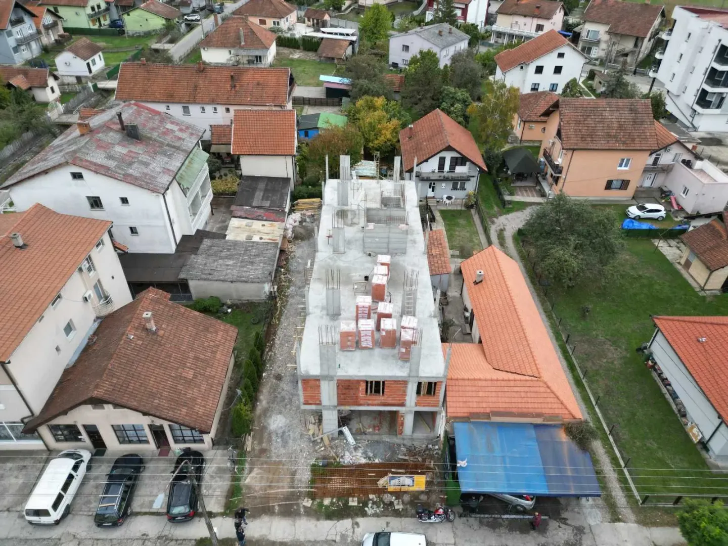 Pogled iz vazduha na gradilište i okolne kuće u naselju.
