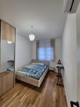 Uređena spavaća soba sa bračnim krevetom, garderoberom sa ogledalom i laminatom. - image 10