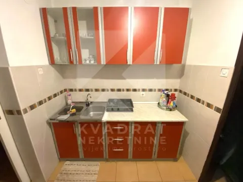 Small kitchen with a sink and orange wall cabinets. - image 6