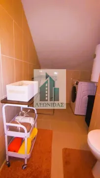 Bathroom with a washing machine, towel cart, and toilet. - image 20