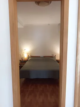 View through the doorway into a tidy bedroom with a double bed. - image 7