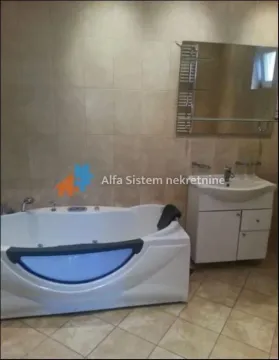 Bathroom equipped with a hydromassage bathtub, vanity unit with sink, and a mirror. - image 10