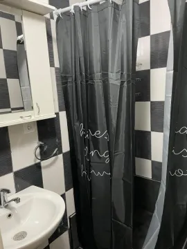 Bathroom with a sink, mirror, and a shower stall with a black curtain. - image 13