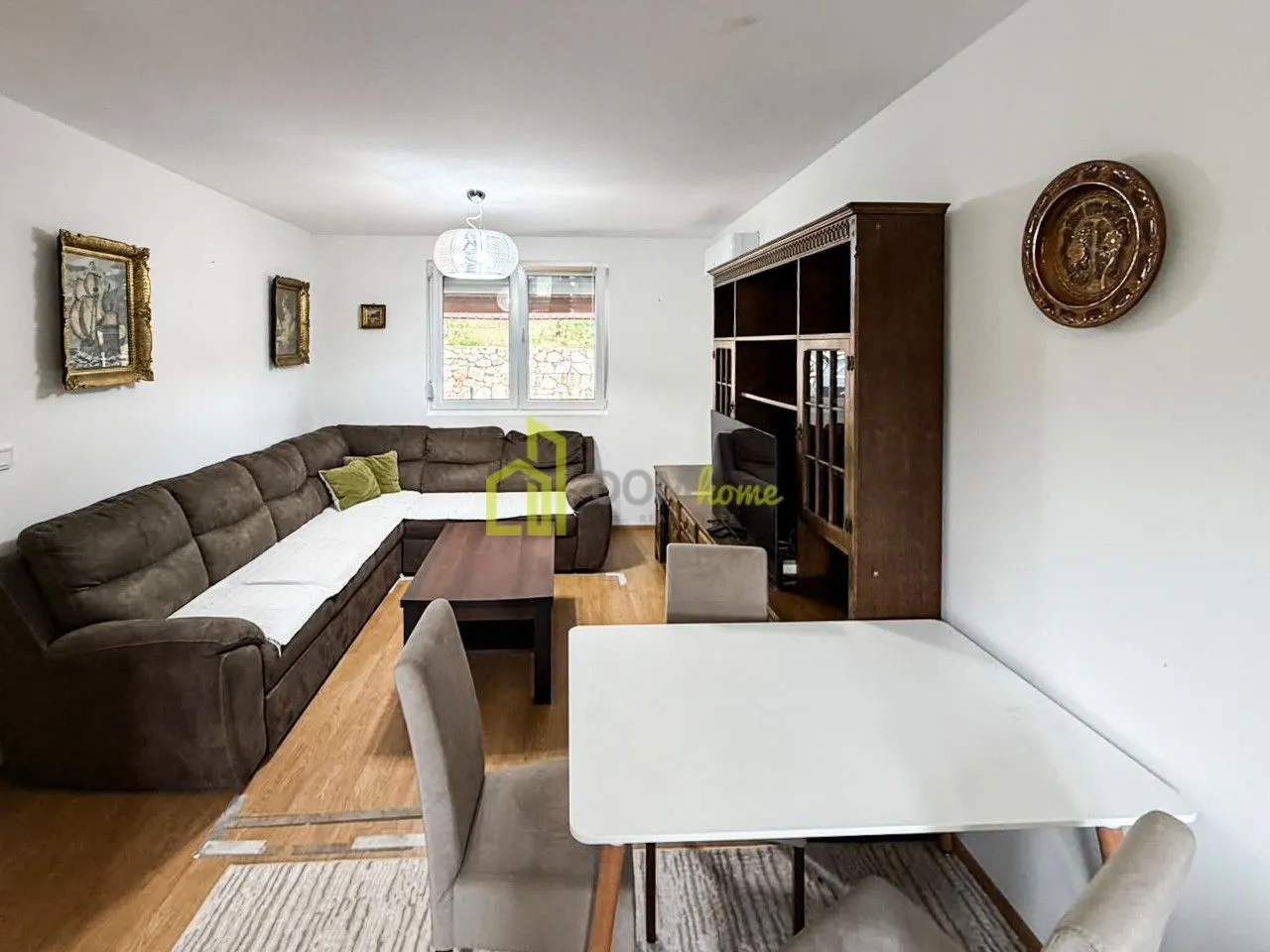 Living room with a sofa set, dining table and wooden furniture.