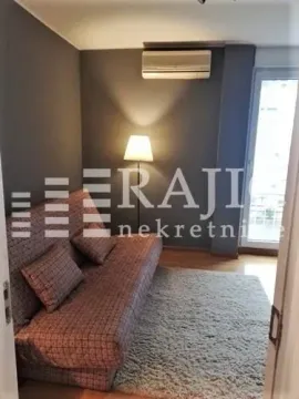 Living room with a sofa, rug, and lamp. - image 10