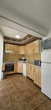 Fully equipped kitchen with wooden cabinetry and white goods. - image 2
