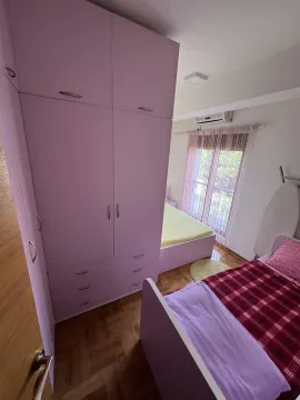 Bright bedroom with pink wardrobes and two beds. - image 7