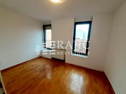 Empty room with hardwood floors and two windows. - image 7